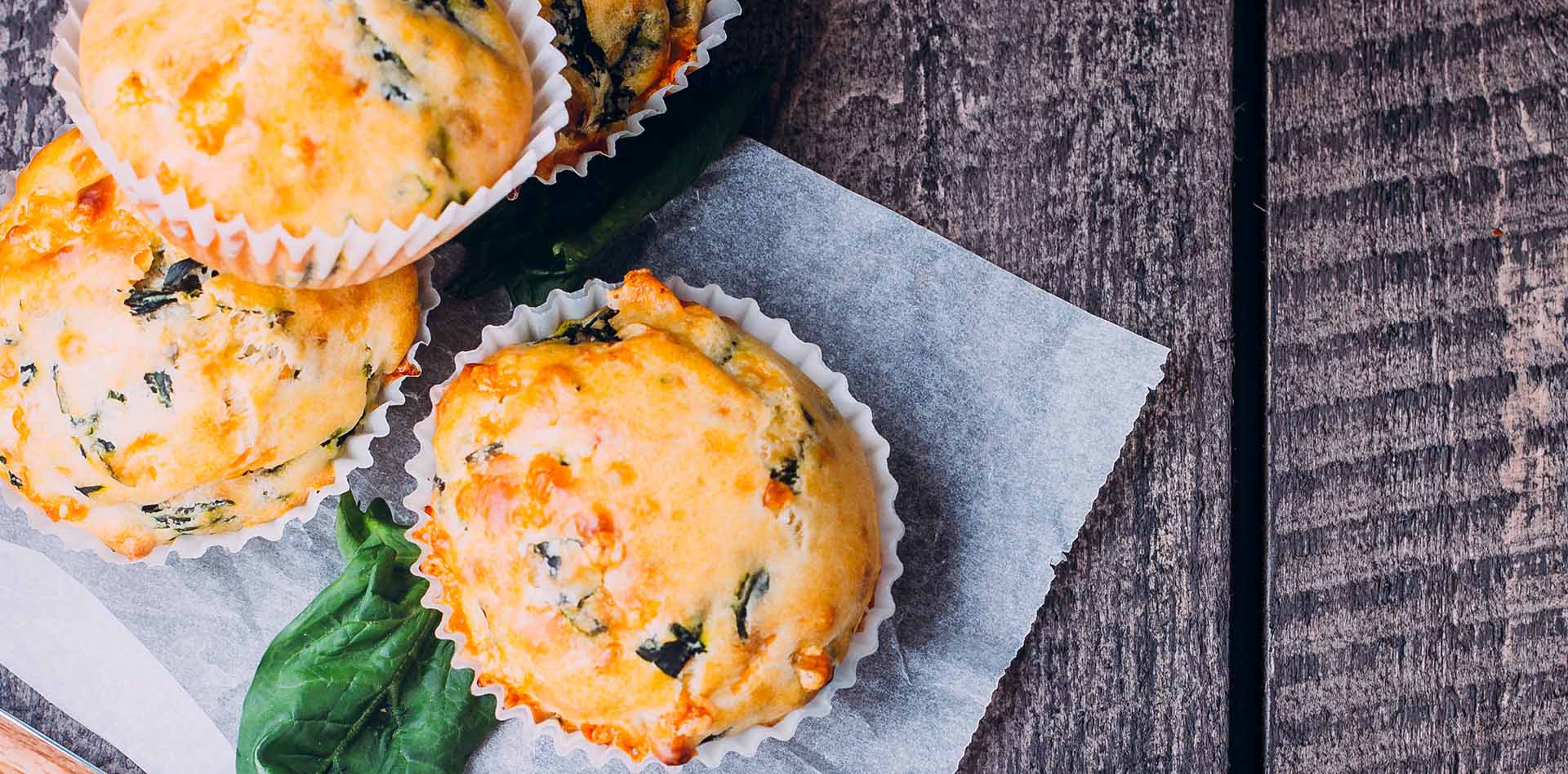 savoury muffins with spinach on wooden background